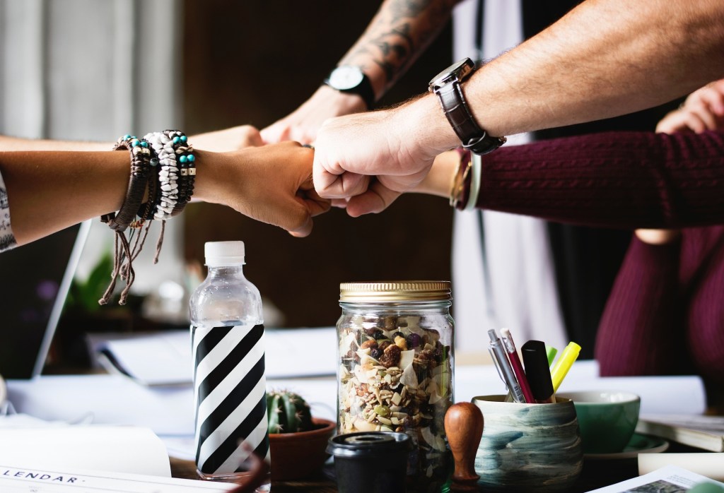 a group of hands participating in a fist bump